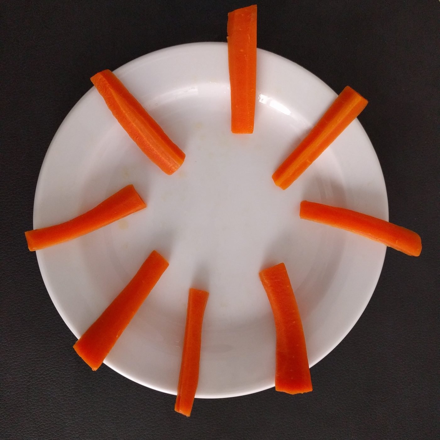 Gulerodsstave placeret på en hvid tallerken