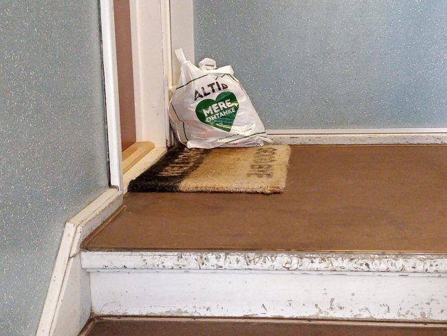 En plastikpose med affald i trappeopgangen. På posen står der "Altid mere omtanke"