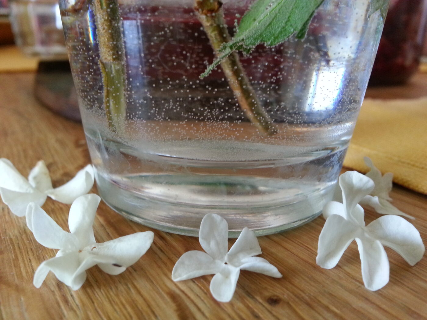 Blomster drysset på et bord omkring en vase.